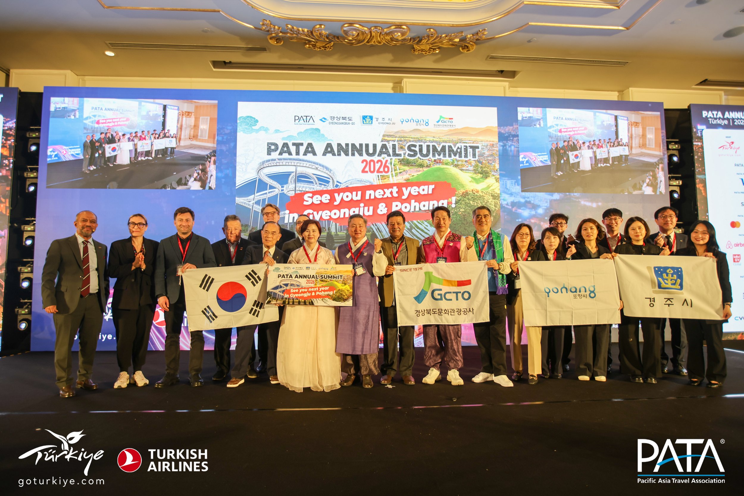 Photo: L/R and Front/Back: Noor Ahmad Hamid, CEO, PATA; Seha Şenol, Corporate & Cultural Events Manager, TGA; Mehmethan Kelkit, Corporate & Cultural Events Director, TGA; Luzi Matzig, Executive Board member, PATA; Jae Pil Sho, Editor & Publisher, TRAVEL PRESS-Korea; Peter Semone, Chair, PATA; Chaewan Im, Director, Gyeongsangbuk-do Tourism Policy Division; Ozan Ortaç, Corporate Communications Director, International Markets, TGA; Lee Dongup, Chairperson, Gyeongsangbuk-do Cultural & Environmental Committee; Suman Pandey, Vice-Chair, PATA; Kim Namil, President, Gyeongsangbuk-do Culture & Tourism Organization; Henry Oh, Board member, PATA; and the Korean Delegation at the official handover ceremony during PATA Annual Summit 2025.